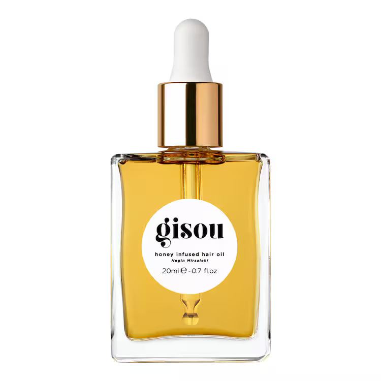 Base. Packshot de un frasco de aceite capilar sobre fondo blanco y, generado con IA, el mismo frasco medio enterrado en arena clara bajo sol directo.